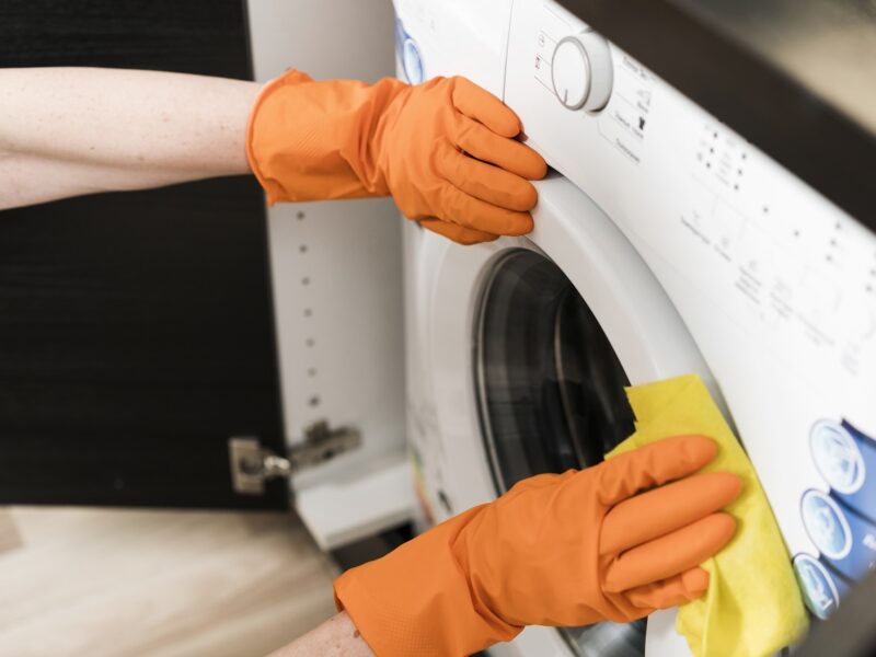 high-angle-woman-cleaning-washing-machine