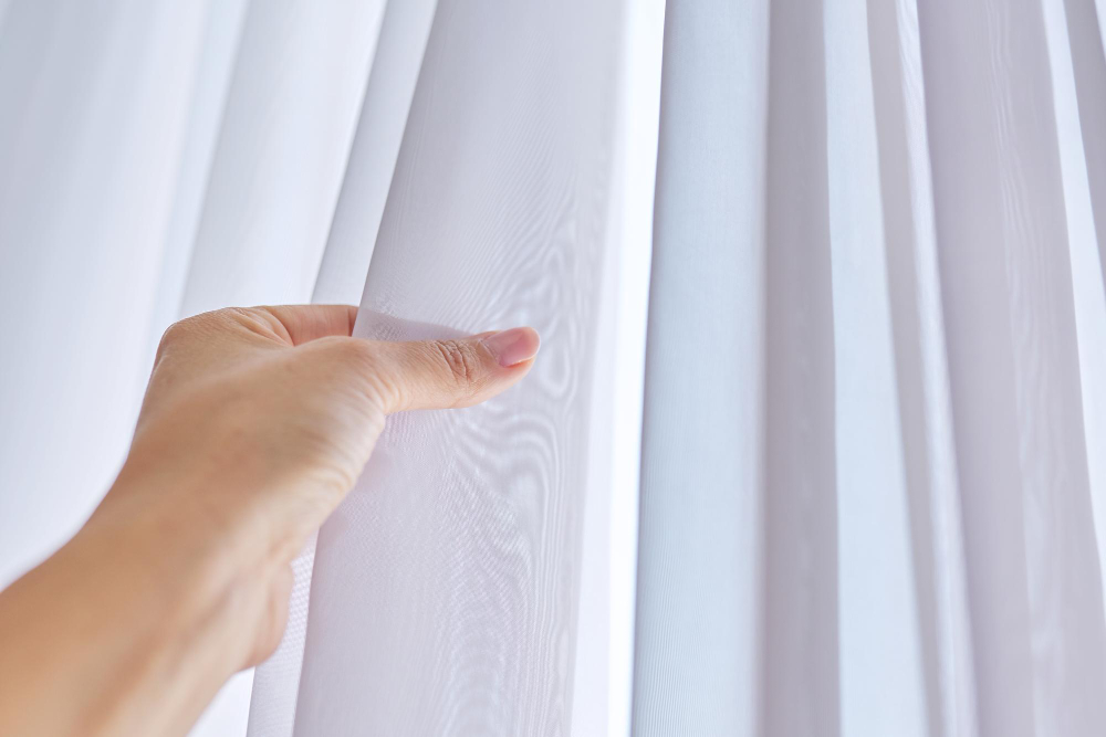 close-up-white-tulle-curtain-window-woman-hand-touching-fabric