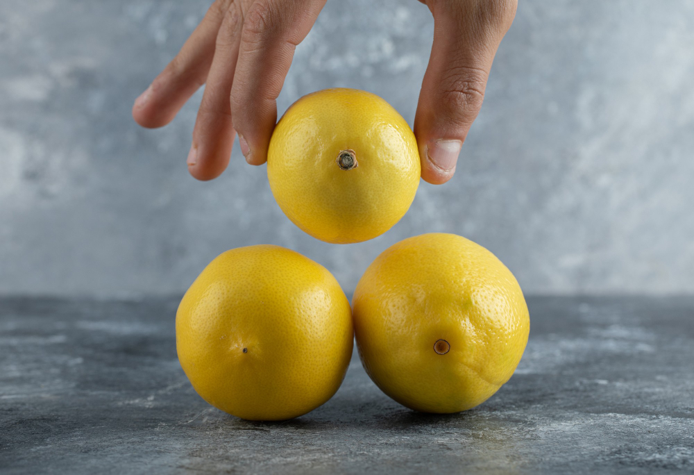 male-hand-taking-fresh-lemon-from-stack