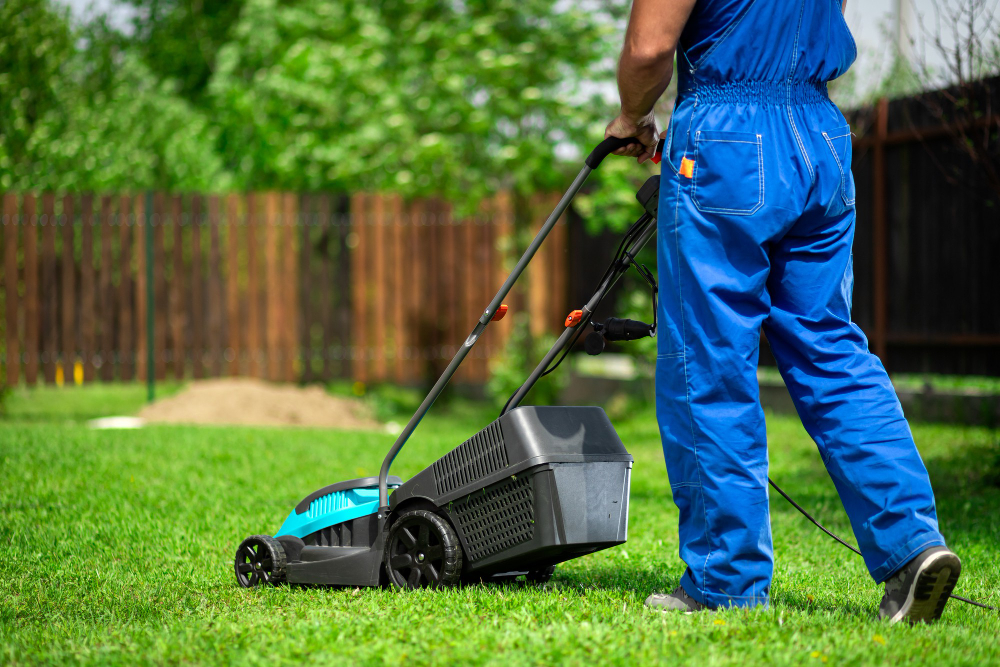 man-with-electric-lawn-mower-mowing-lawn