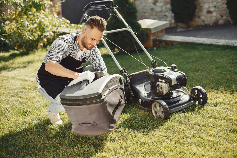 man-cutting-grass-with-lawn-mover-back-yard-male-black-apron-guy-repairs