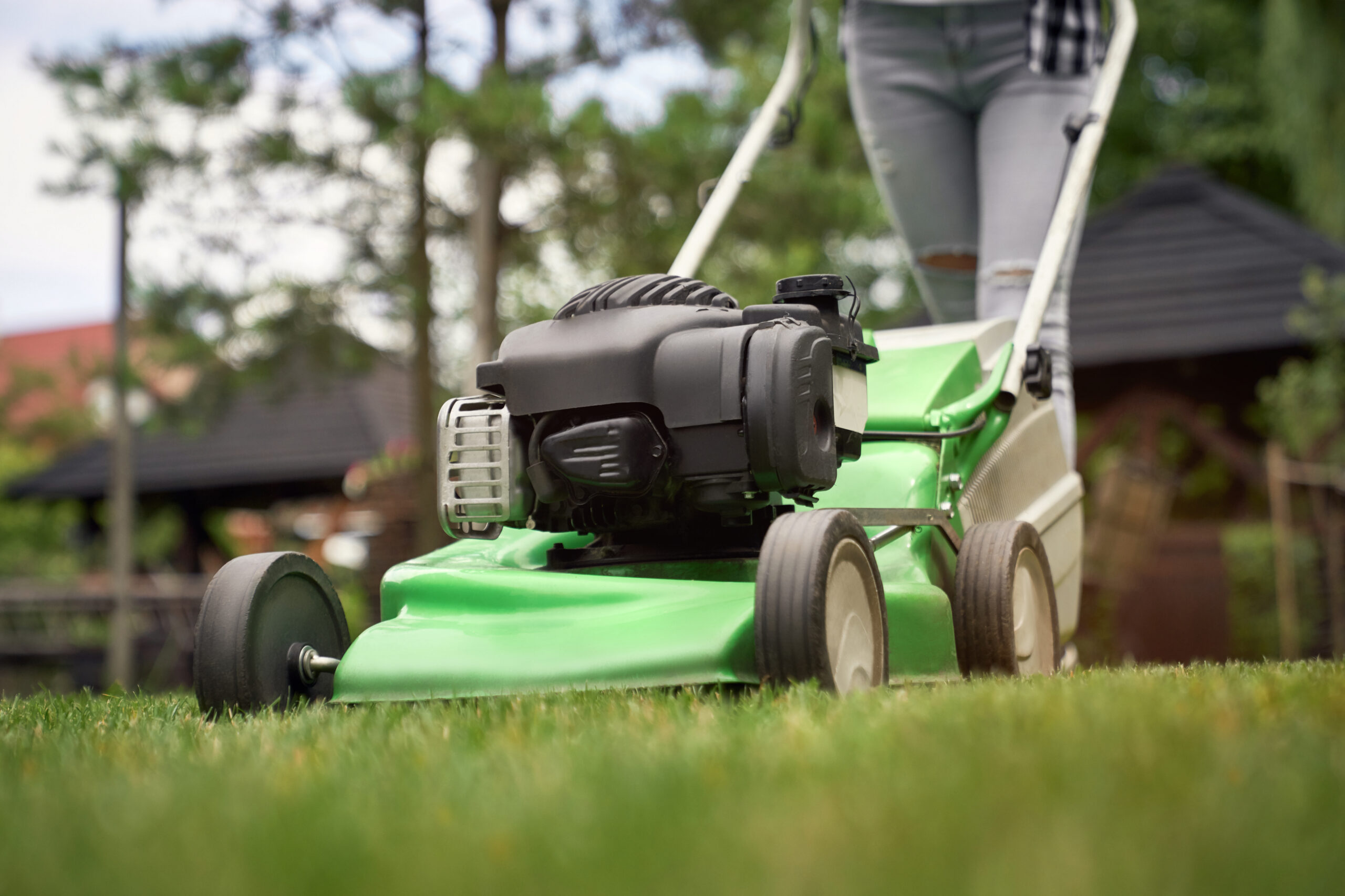 Female Legs Of Woman Using Lawn Mower.