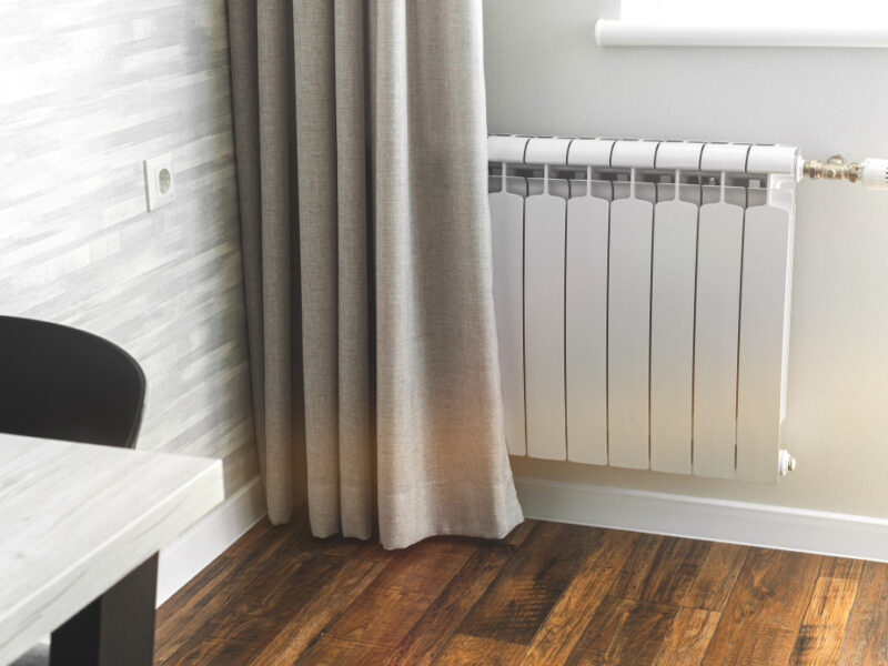 heating-metal-radiator-white-radiator-modern-apartment-interior-with-wooden-floor