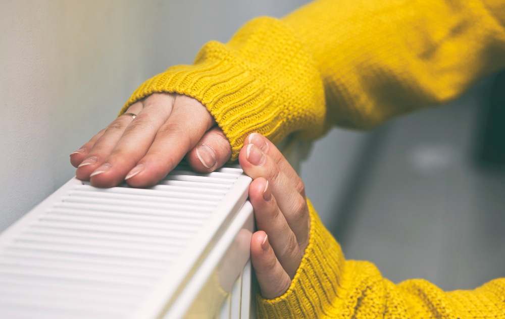 woman-warms-her-hands-radiator