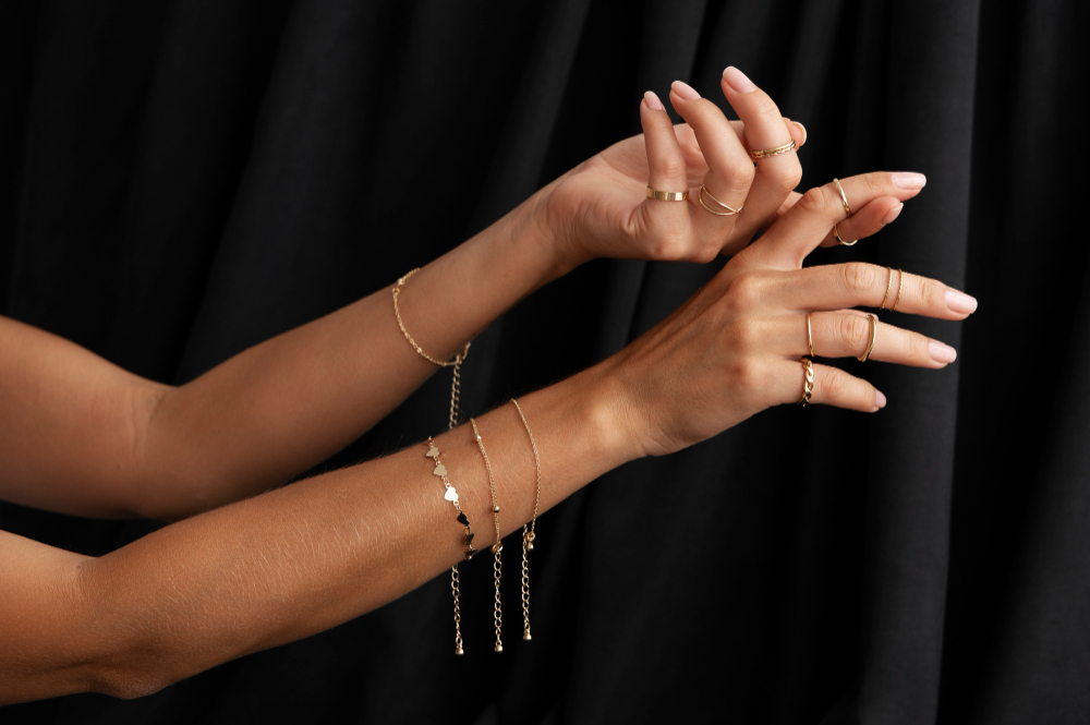 woman-s-arms-wearing-golden-jewelry