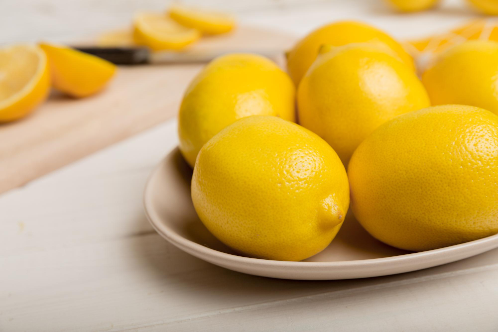 fresh-cutted-lemon-whole-lemons-round-plate-colored-background-food-drink-ingredients-preparing-healthy-eating-theme-top-view-vith-copy-space