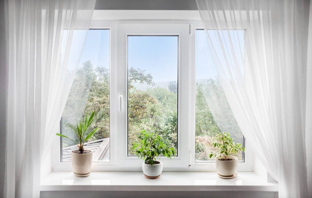 window-with-white-tulle-potted-plants-windowsill-view-nature-from-window