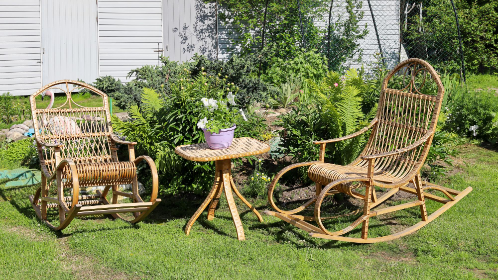 rocking-chair-recreation-from-rattan-small-wicker-table-near-flower-bed