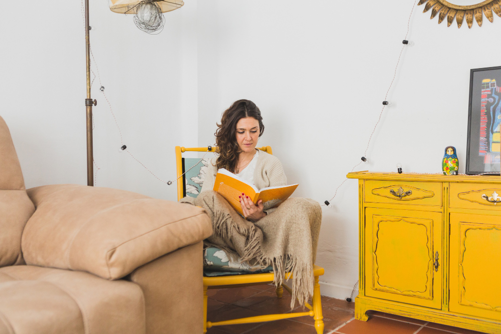 concentrated-girl-reading-book-sitting-yellow-chair
