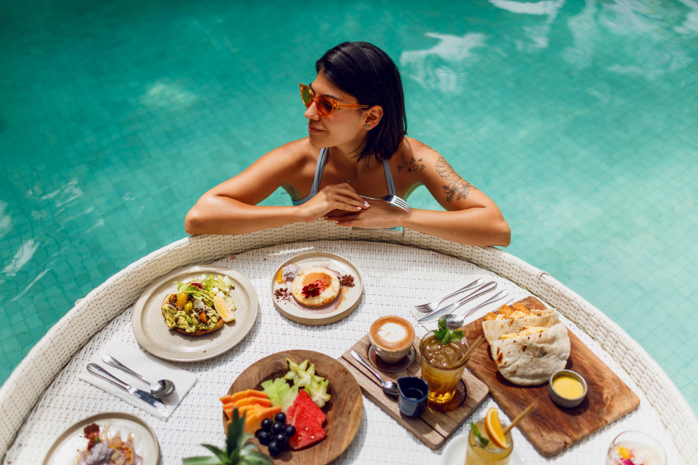 young-sexy-woman-with-tattoo-bathing-suit-having-breakfast-private-pool-girl-relaxing-pool-drinking-coffee-eating-fruits-fruit-plate-smoothie-bowl-by-hotel-pool