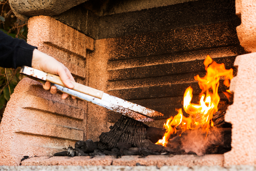 Person Hand Burning Coal With Tong Firepit