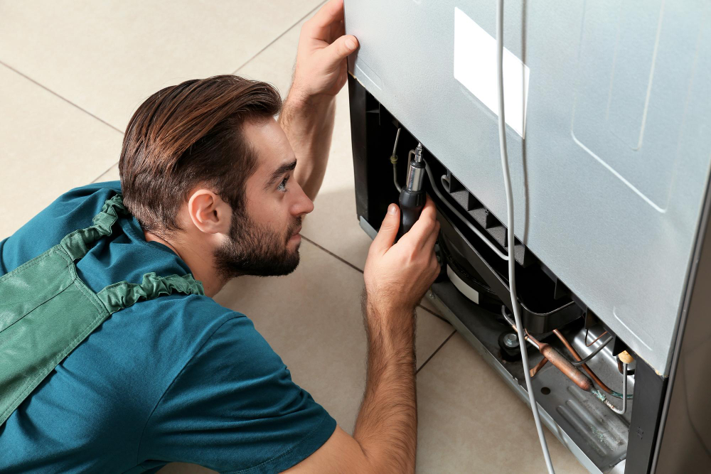 Male Technician Repairing Refrigerator Indoors