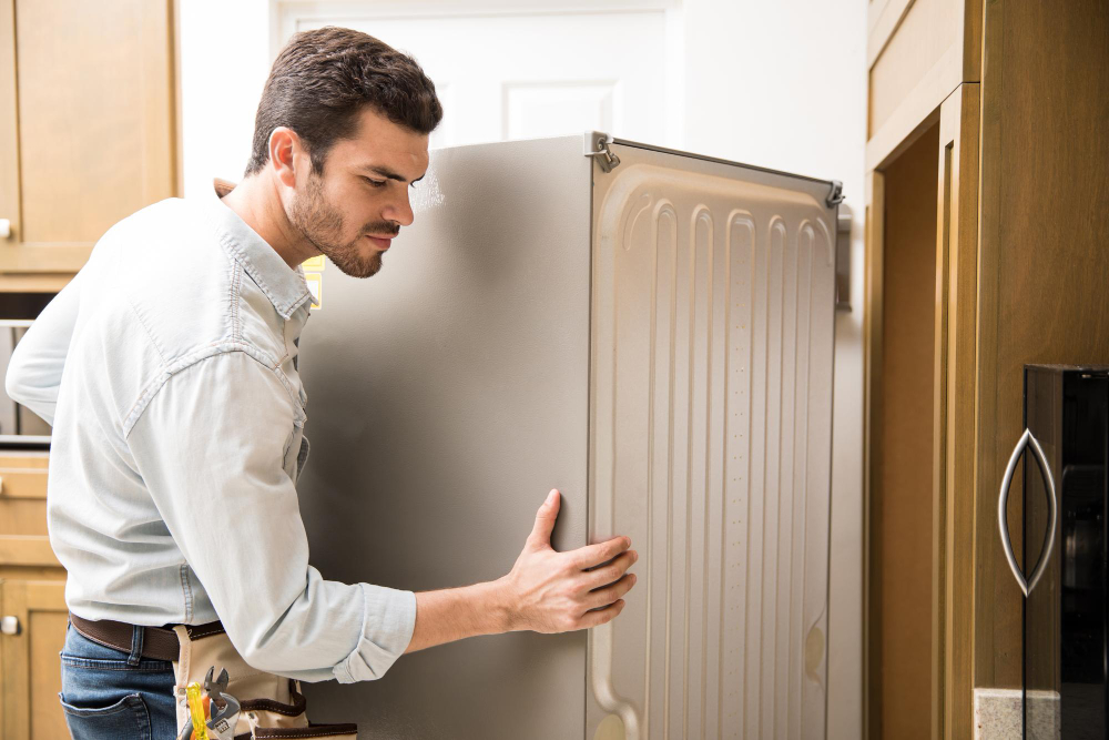 Young Man Working As Electrician Exposing Back Fridge Check Repair It