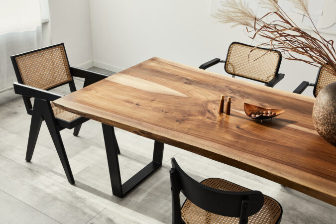 Interior Design Of Stylish Dining Room Interior With Family Wooden Table, Modern Chairs, Plate With Nuts, Salt And Pepper Shakers. Concrete Floor. White Wall. Template.