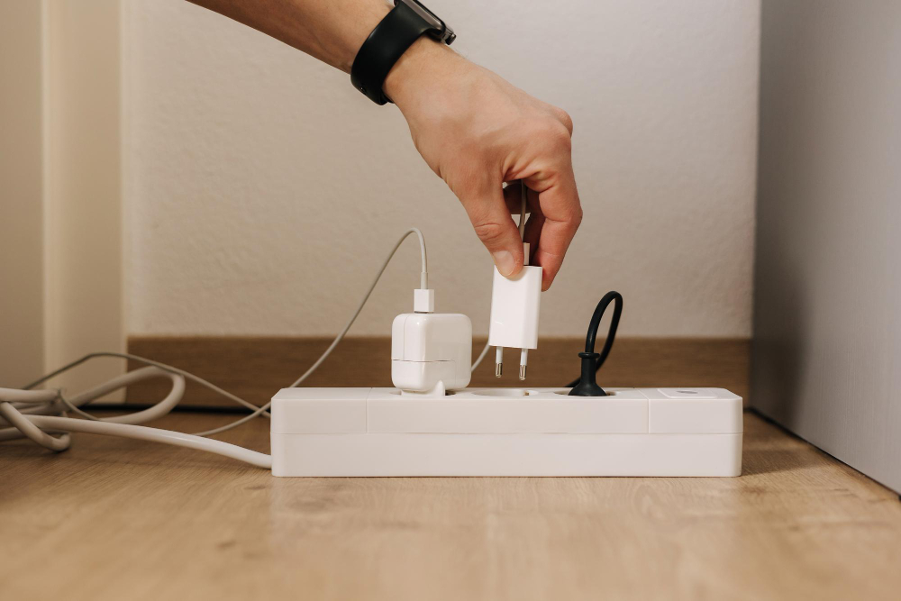 Human Hand Puts Charger Into Filled Extension Cord White Cable Connector Closeup Home Routine