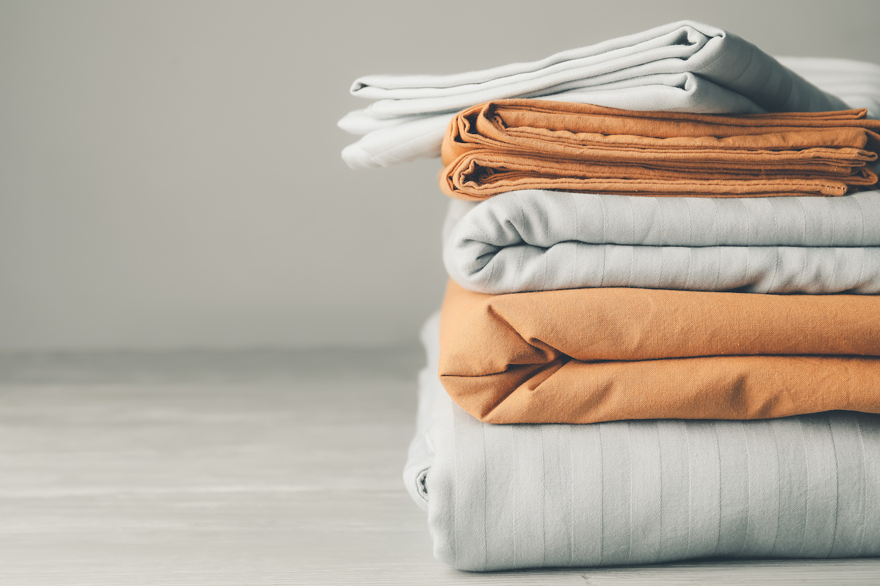 Stack Of Clean Bed Sheets On Table