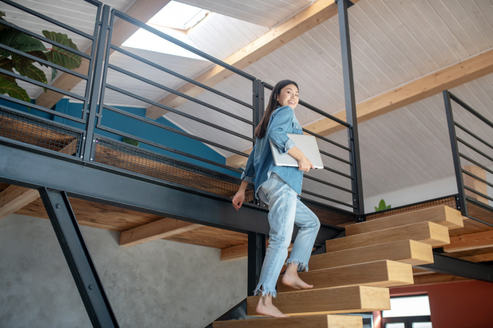 Young Woman Going Upstairs Holding Laptop Arm Smiling